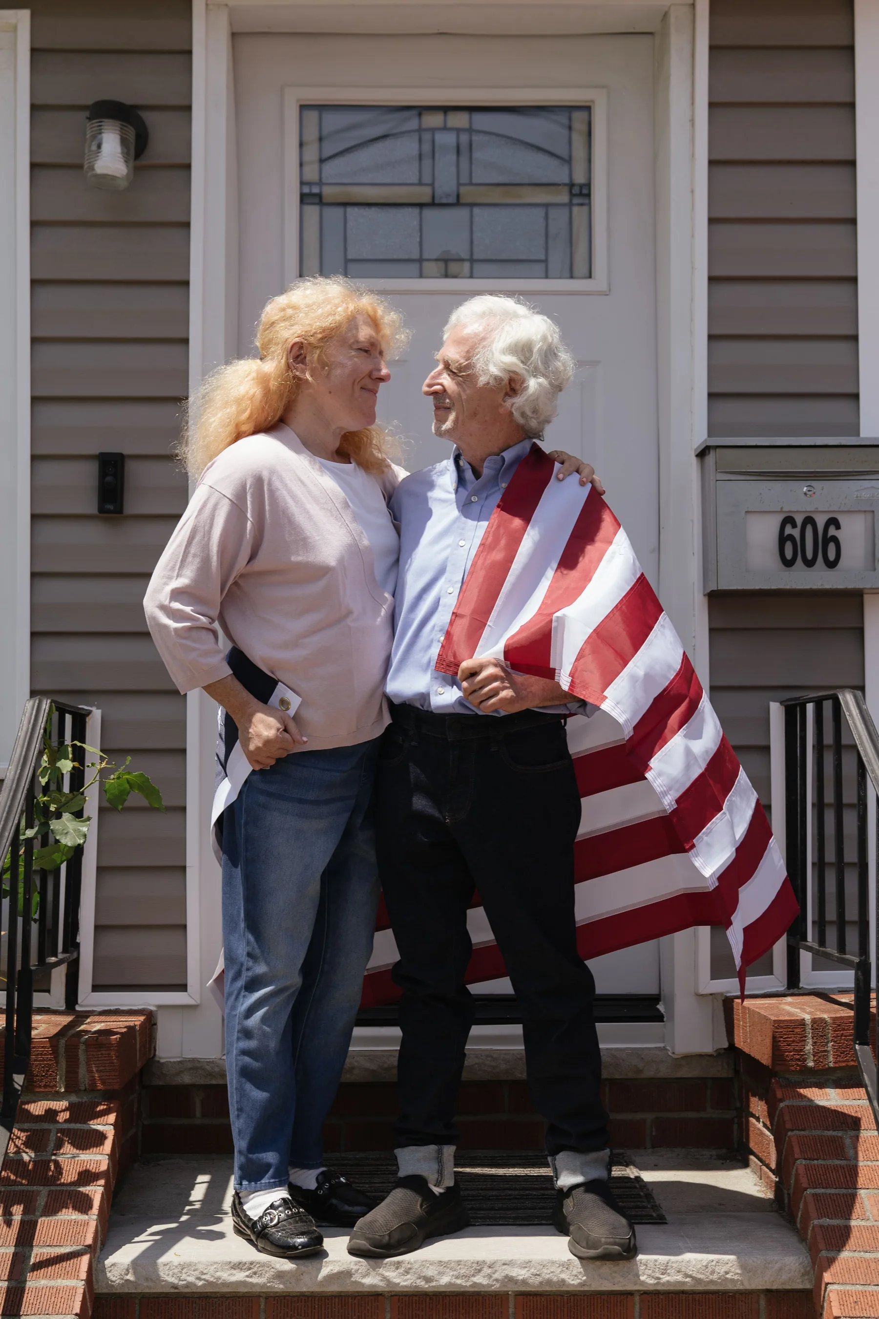 Older American couple standing together outside their home